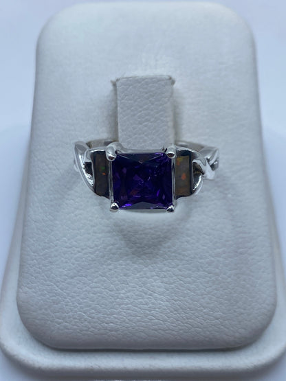 Anillo de plata con ópalo de fuego natural multicolor en la mano de una mujer