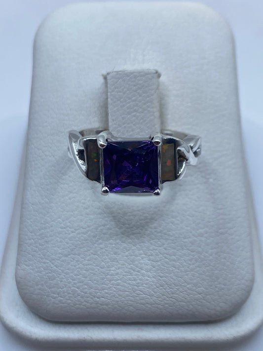 Anillo de plata con ópalo de fuego natural multicolor en la mano de una mujer