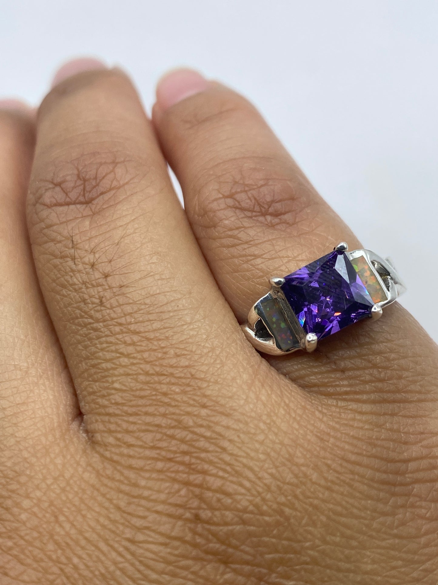 Anillo sobre fondo neutro revelando el sello 925 y el fuego del ópalo natural