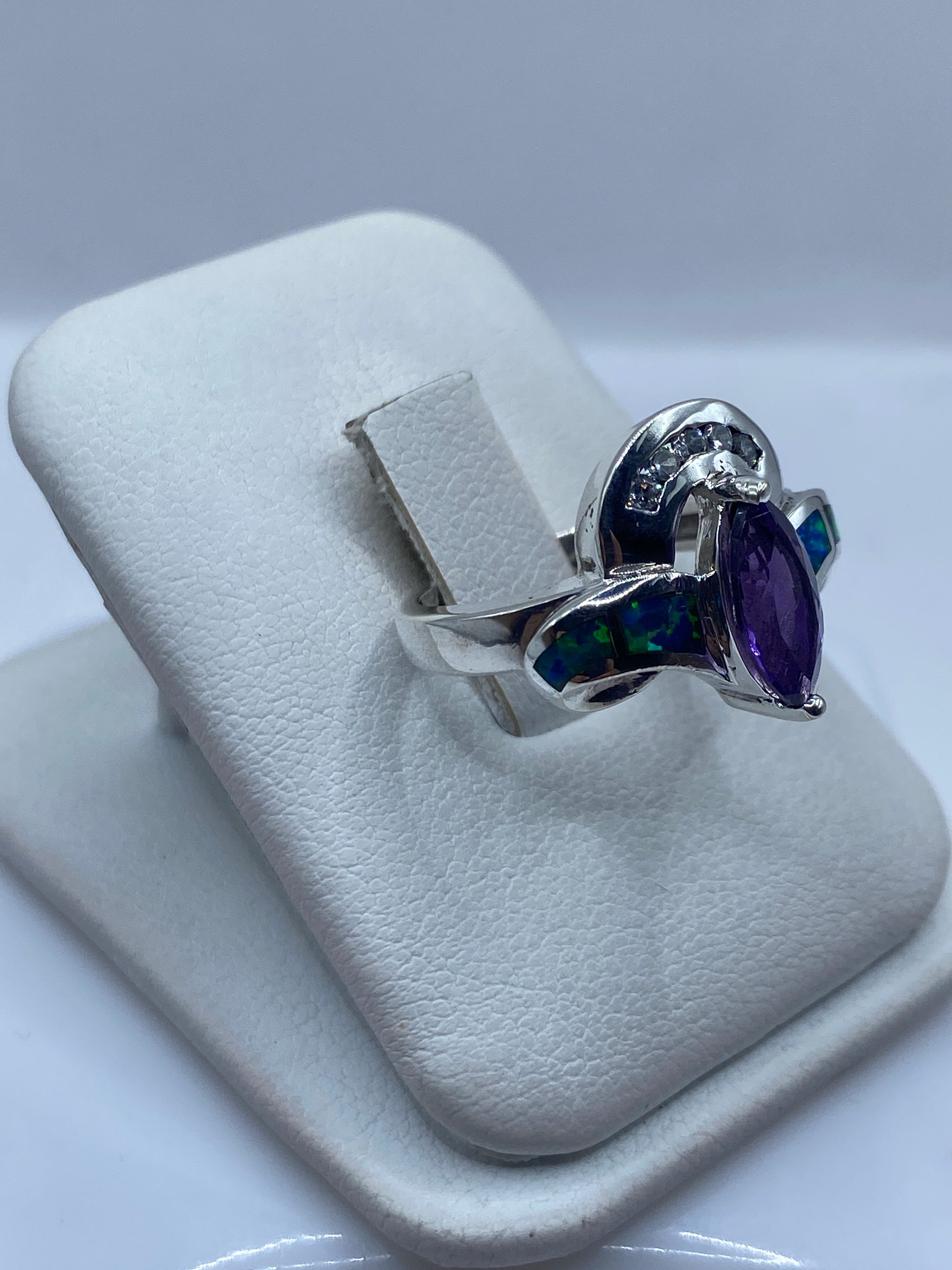 Detalle del ópalo azul mostrando reflejos verdes y dorados en el engaste de plata