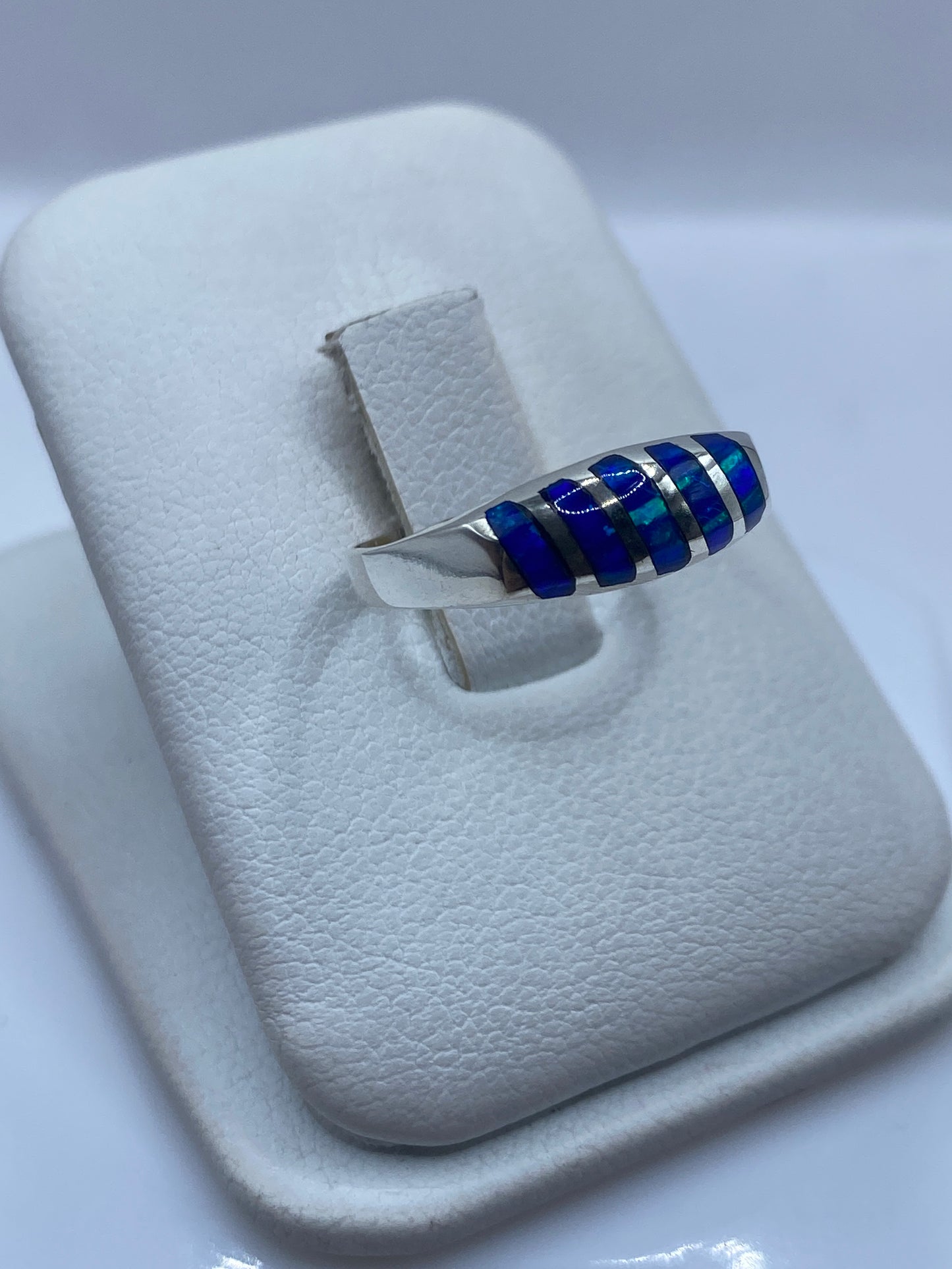 Vista lateral del anillo minimalista con ópalo de fuego azul en plata