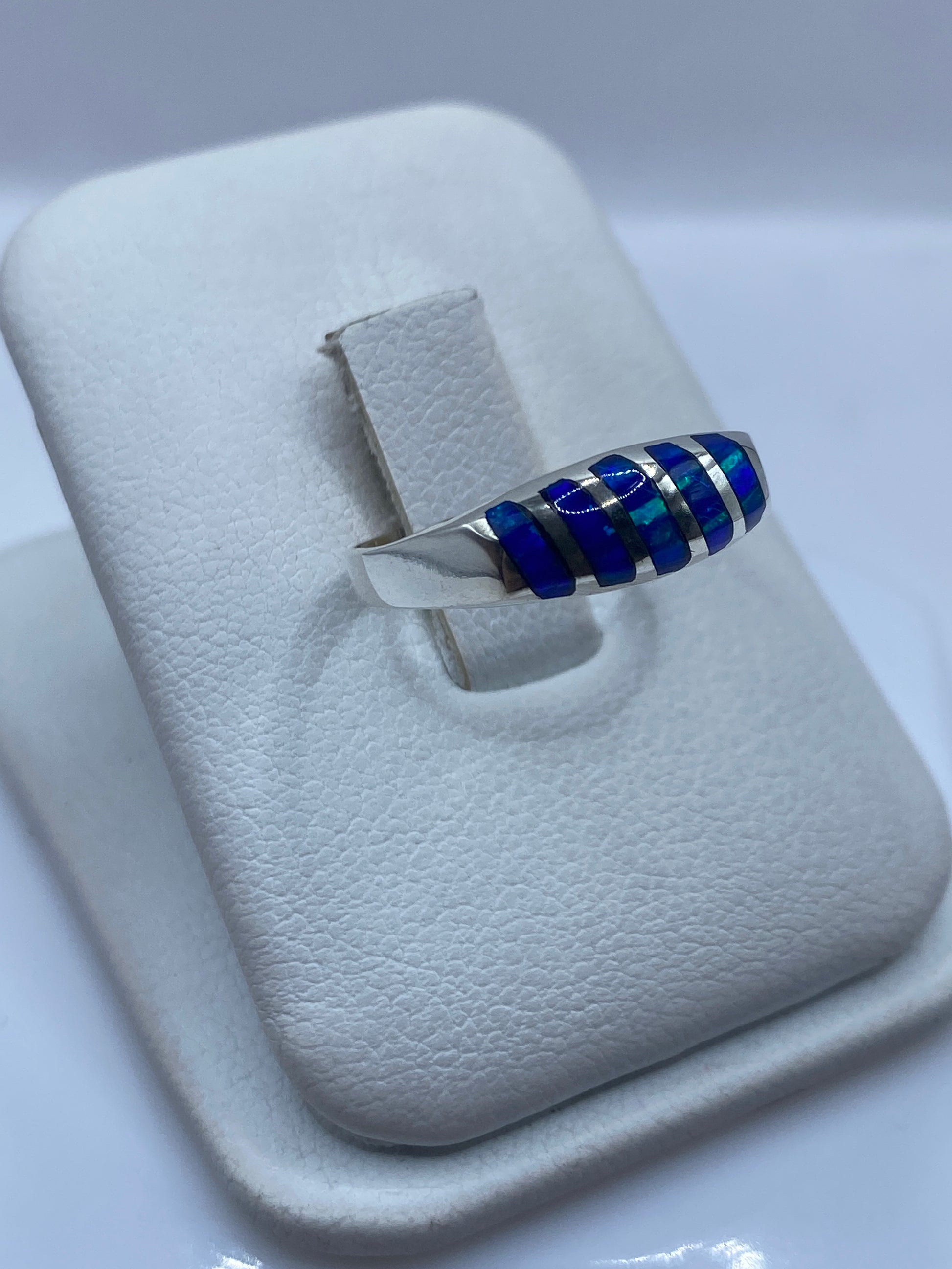 Vista lateral del anillo minimalista con ópalo de fuego azul en plata