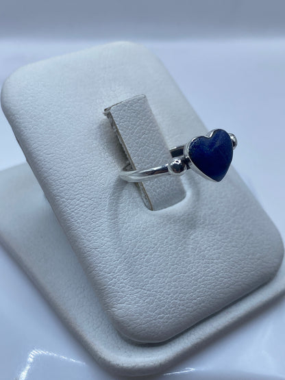 Vista lateral del anillo solitario corazón sobre dedo de mujer