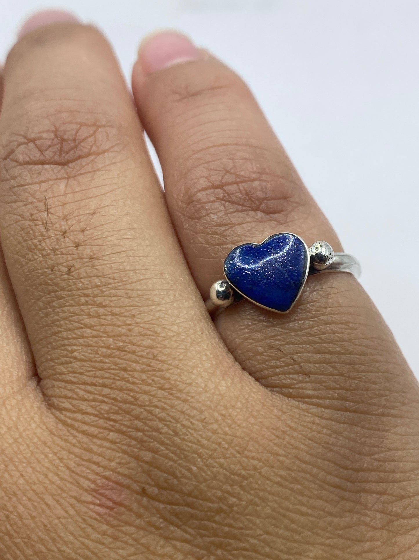 Anillo corazón de circonia en escala de peso, mostrando su delicadeza