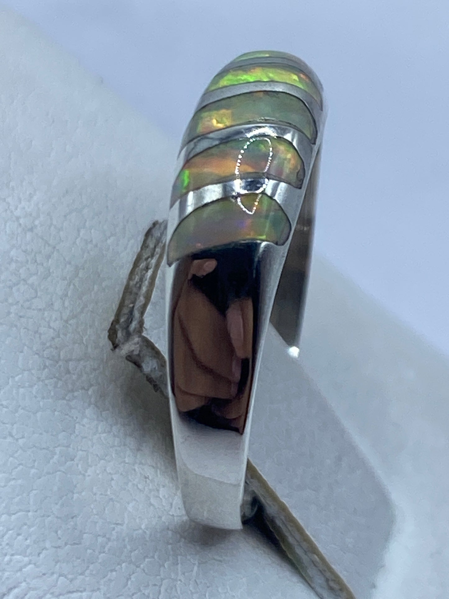 Anillo minimalista de plata pura .950 en la mano, vista frontal del engaste