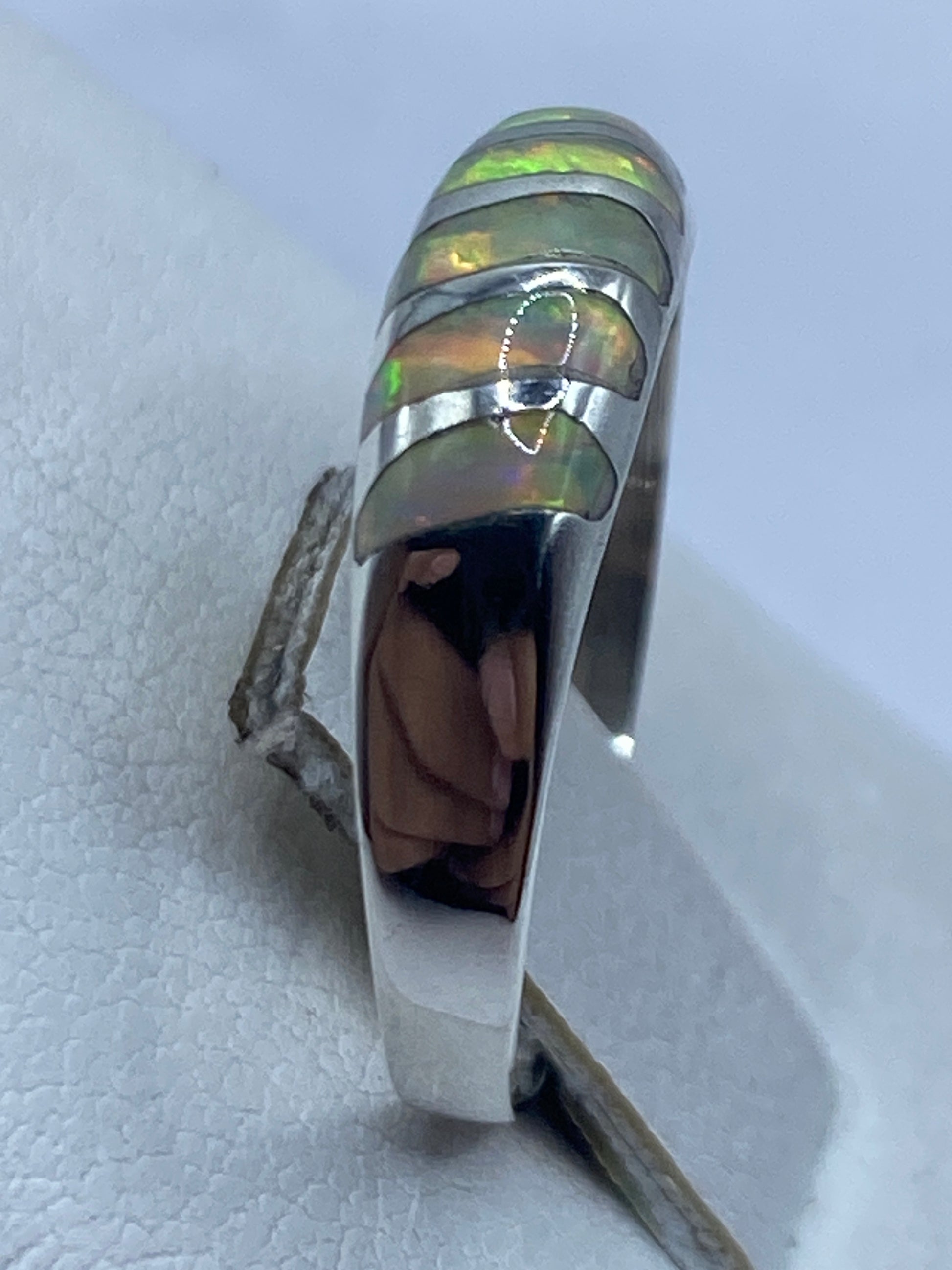 Anillo minimalista de plata pura .950 en la mano, vista frontal del engaste