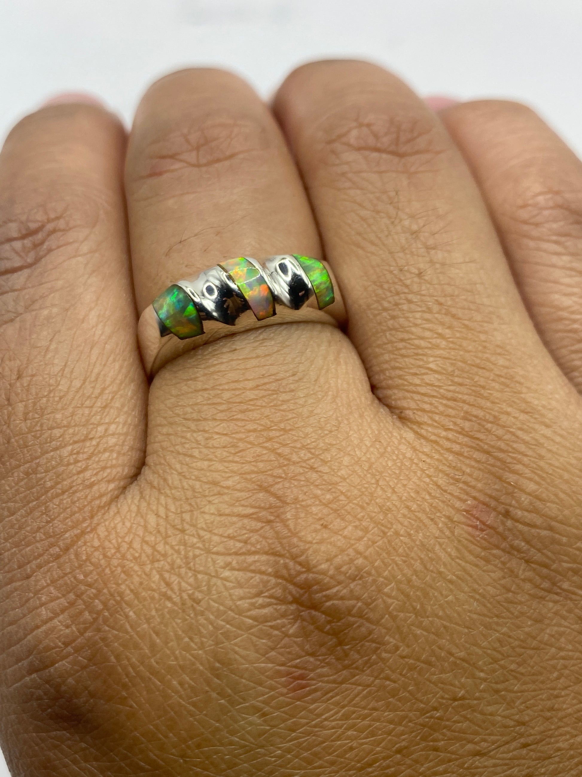 Anillo en mano mostrando el movimiento de colores del ópalo de fuego