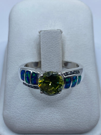 Anillo de plata coctel con ópalo de fuego azul en la mano de una mujer