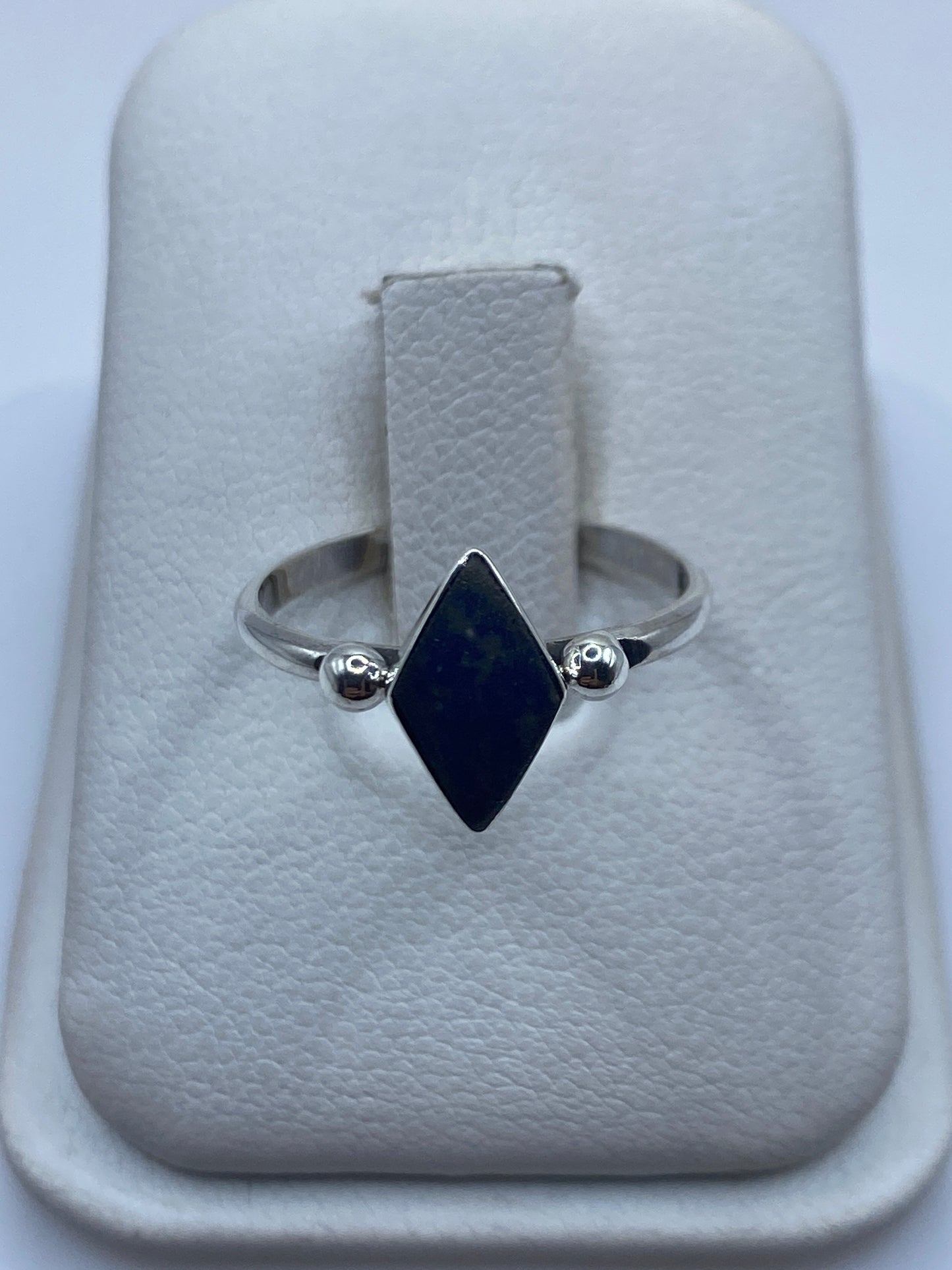 Anillo de plata .950 con onix azul tallado en forma diamante, visto de frente en estuche blanco