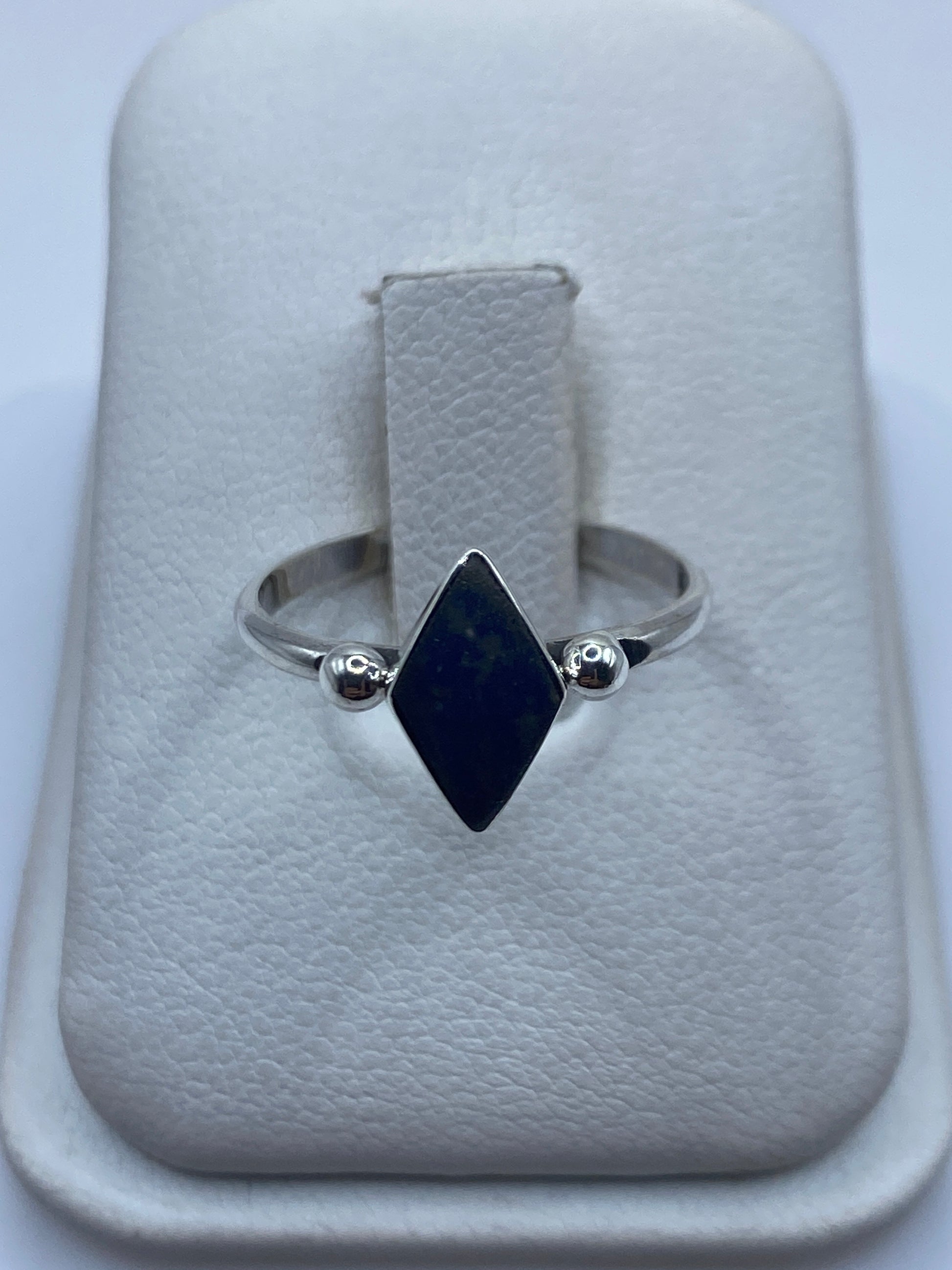 Anillo de plata .950 con onix azul tallado en forma diamante, visto de frente en estuche blanco