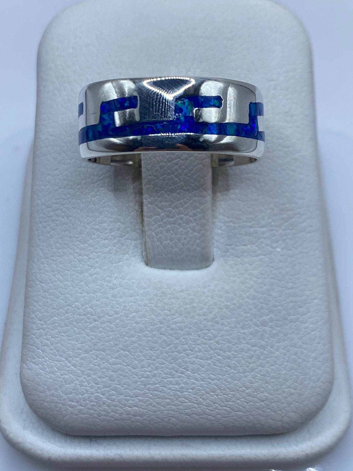 Anillo de plata con ópalo de fuego azul en banda moderna, vista frontal en estuche blanco