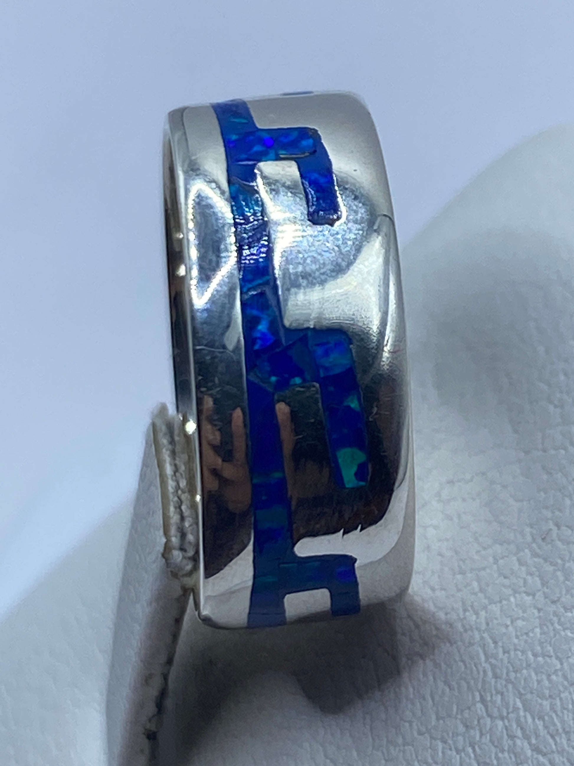 Anillo de plata ópalo azul en la mano mostrando el brillo natural de la piedra
