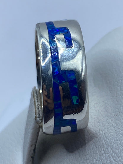 Anillo de plata ópalo azul en la mano mostrando el brillo natural de la piedra