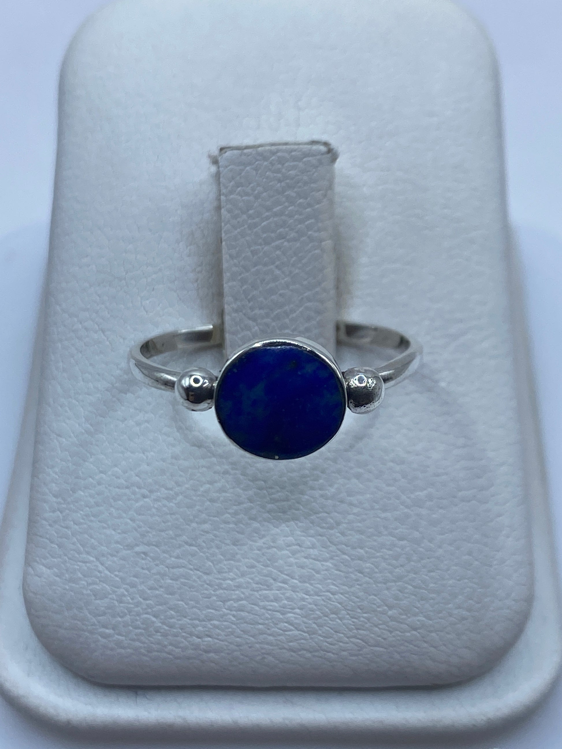 Anillo de plata solitario con lapislázuli azul profundo en la mano de una mujer