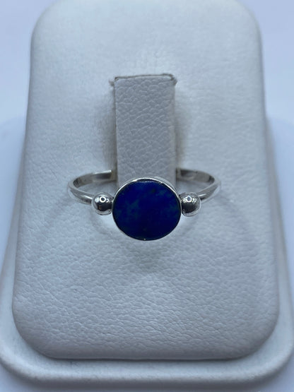 Anillo de plata solitario con lapislázuli azul profundo en la mano de una mujer