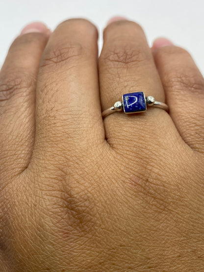 Anillo en dedo de mujer con sello 950 visible, piedra azul profundo