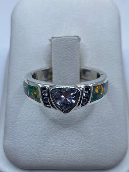 Anillo de plata con ópalo de fuego multicolor mostrando juego de luz en colores verde, azul, rojo y ámbar