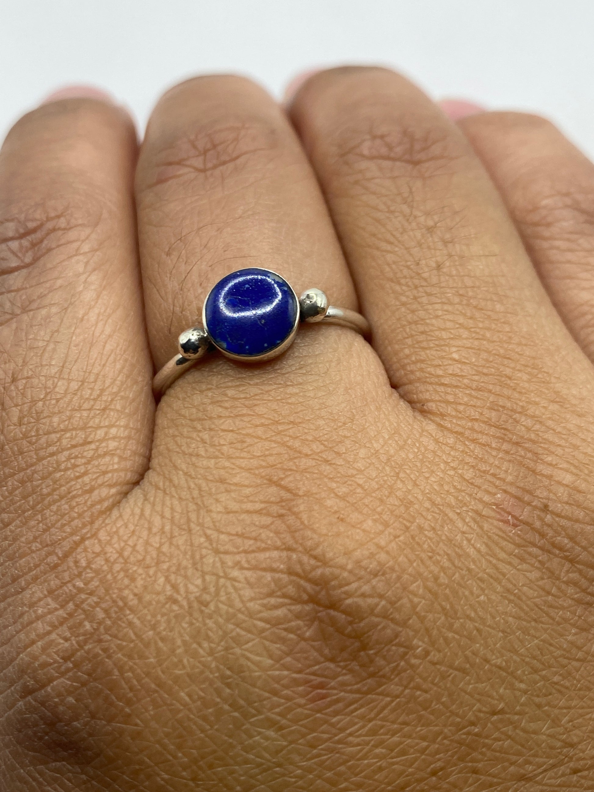 Anillo de plata con lapislázuli puesto en dedo, luz natural