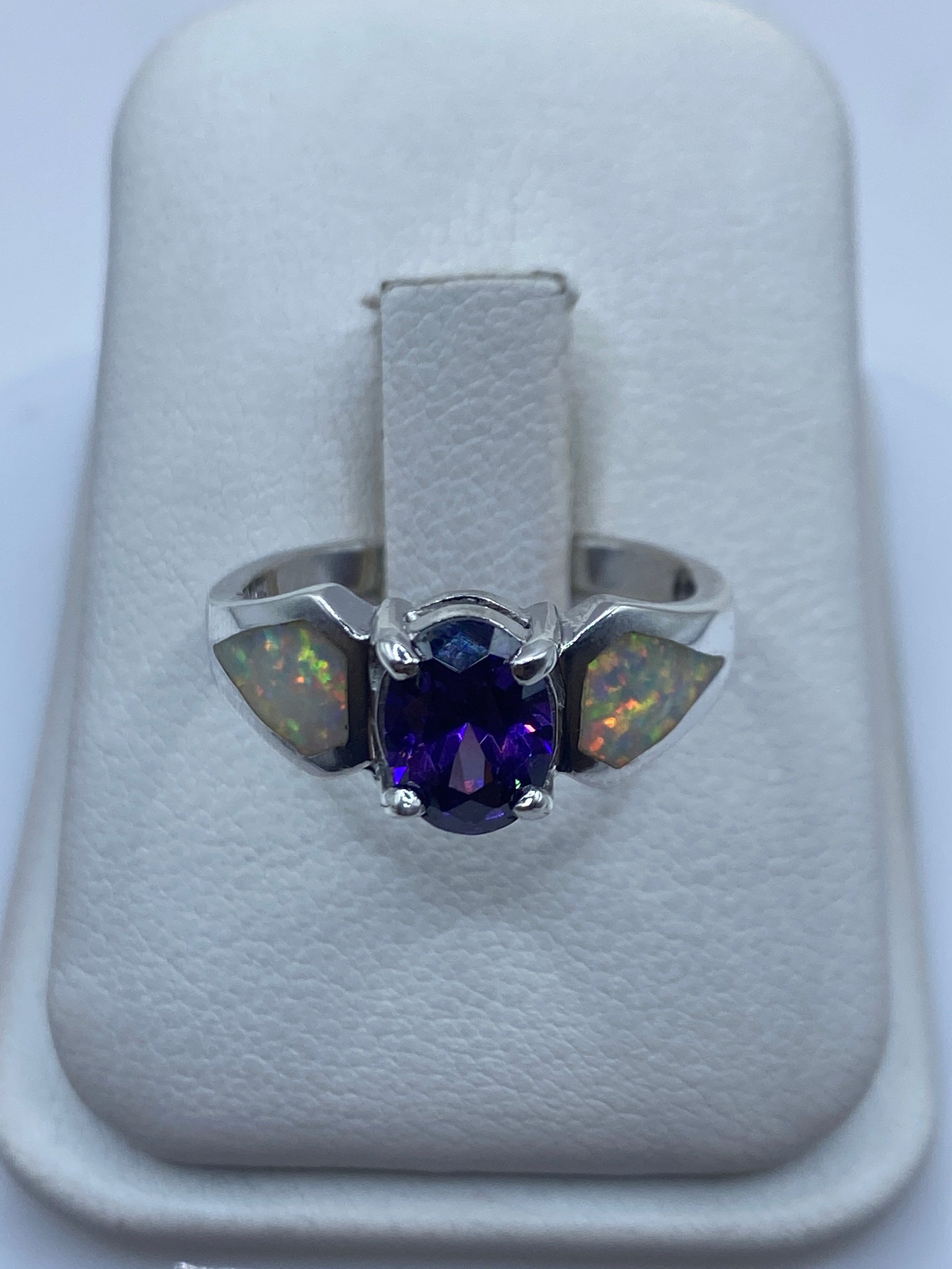 Anillo de plata con ópalo de fuego multicolor mostrando reflejos rojo, naranja y verde en estuche blanco