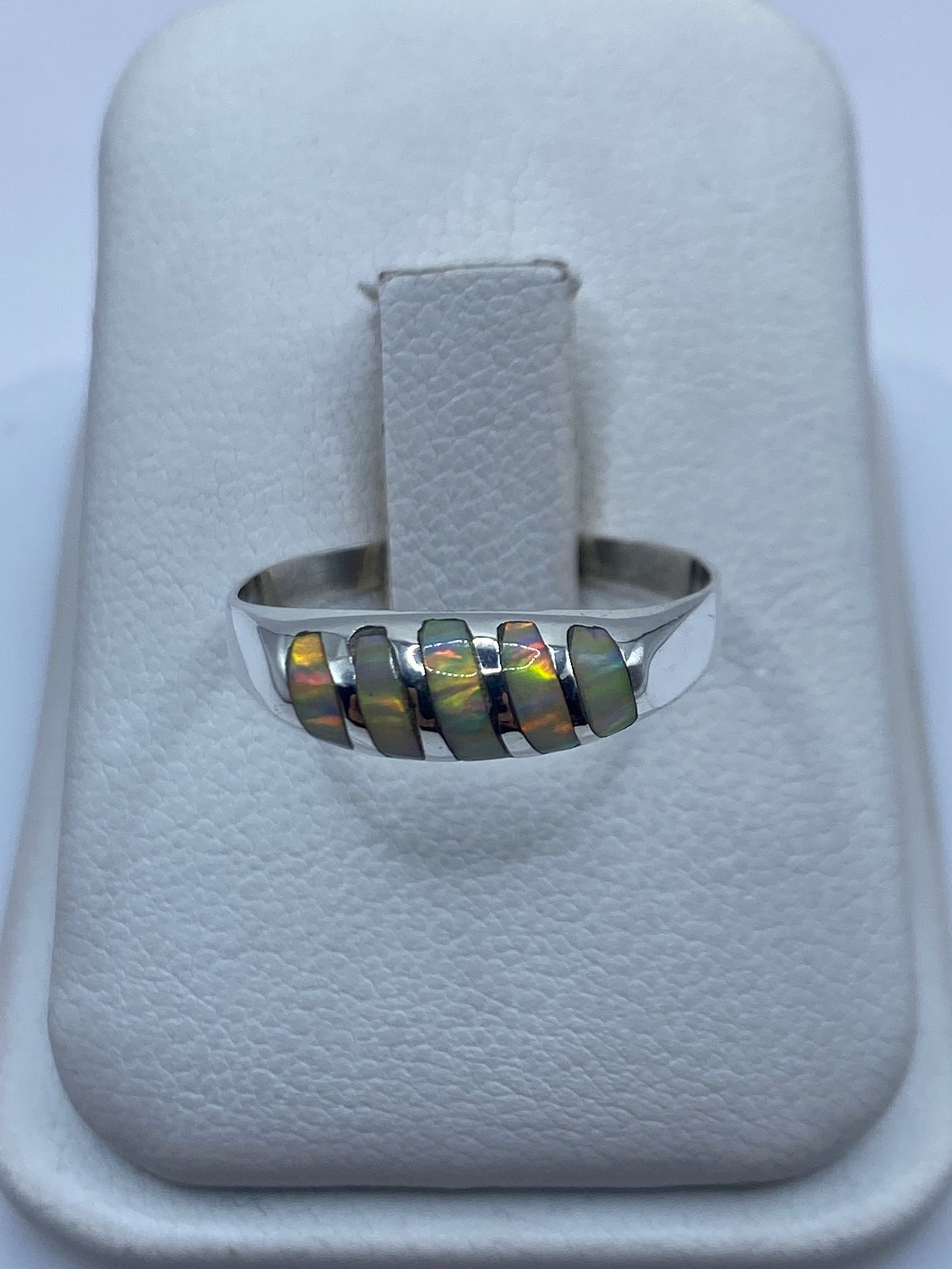 Anillo de plata minimalista con ópalo de fuego multicolor en la mano