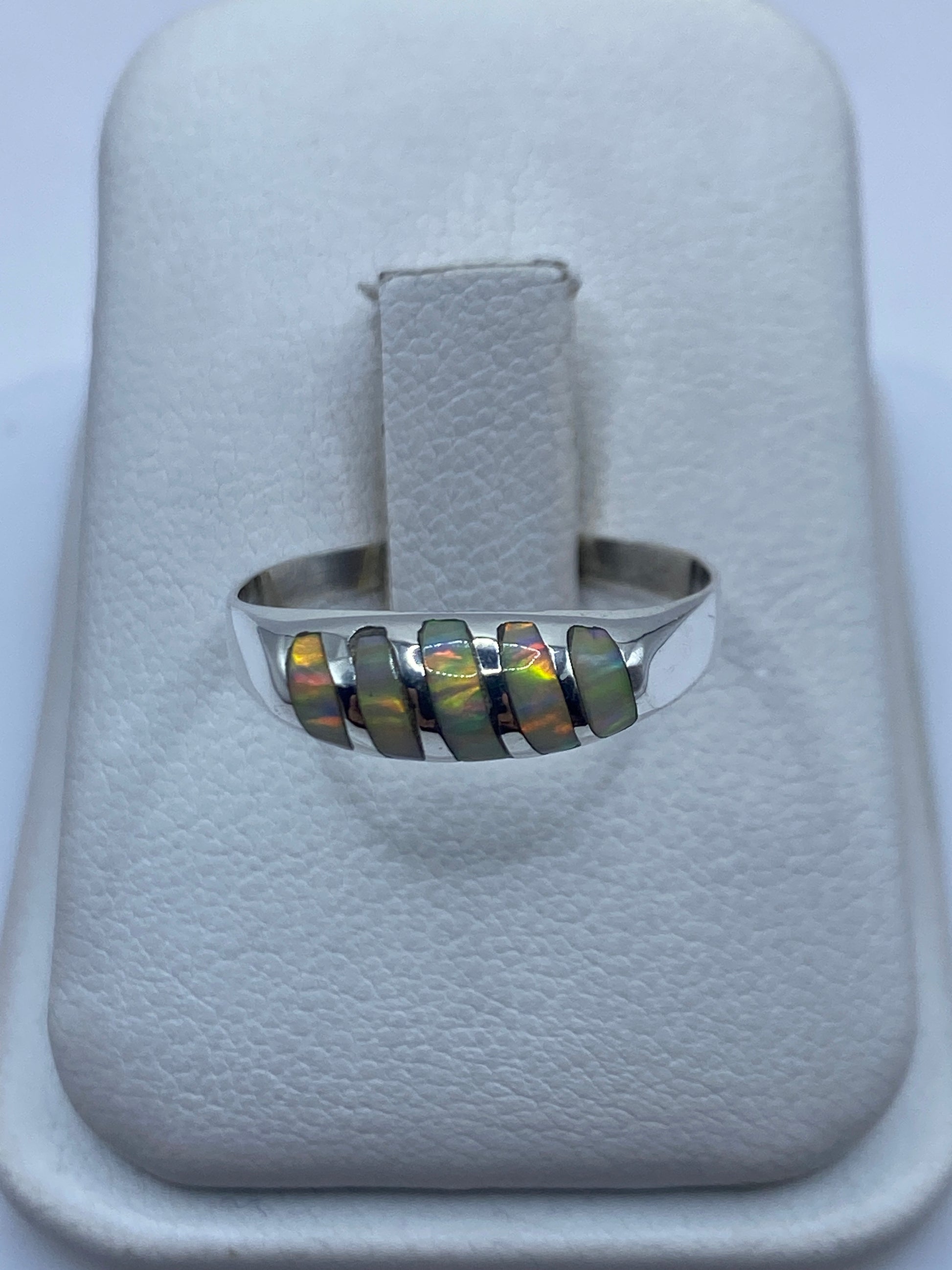 Anillo de plata minimalista con ópalo de fuego multicolor en la mano