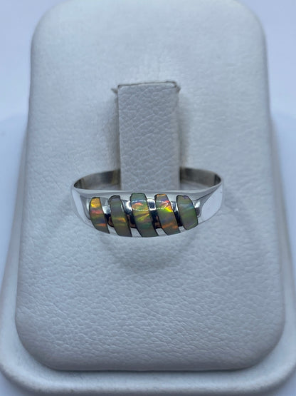 Anillo de plata minimalista con ópalo de fuego multicolor en la mano