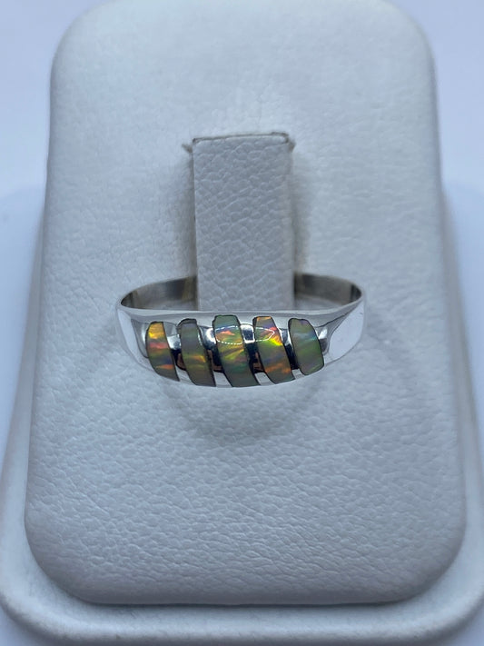 Anillo de plata minimalista con ópalo de fuego multicolor en la mano