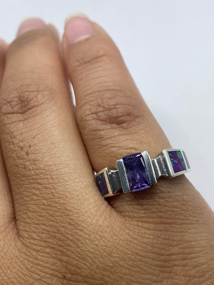 Anillo en dedo con ópalo de fuego brillando en tonos dorados, verdes y púrpuras