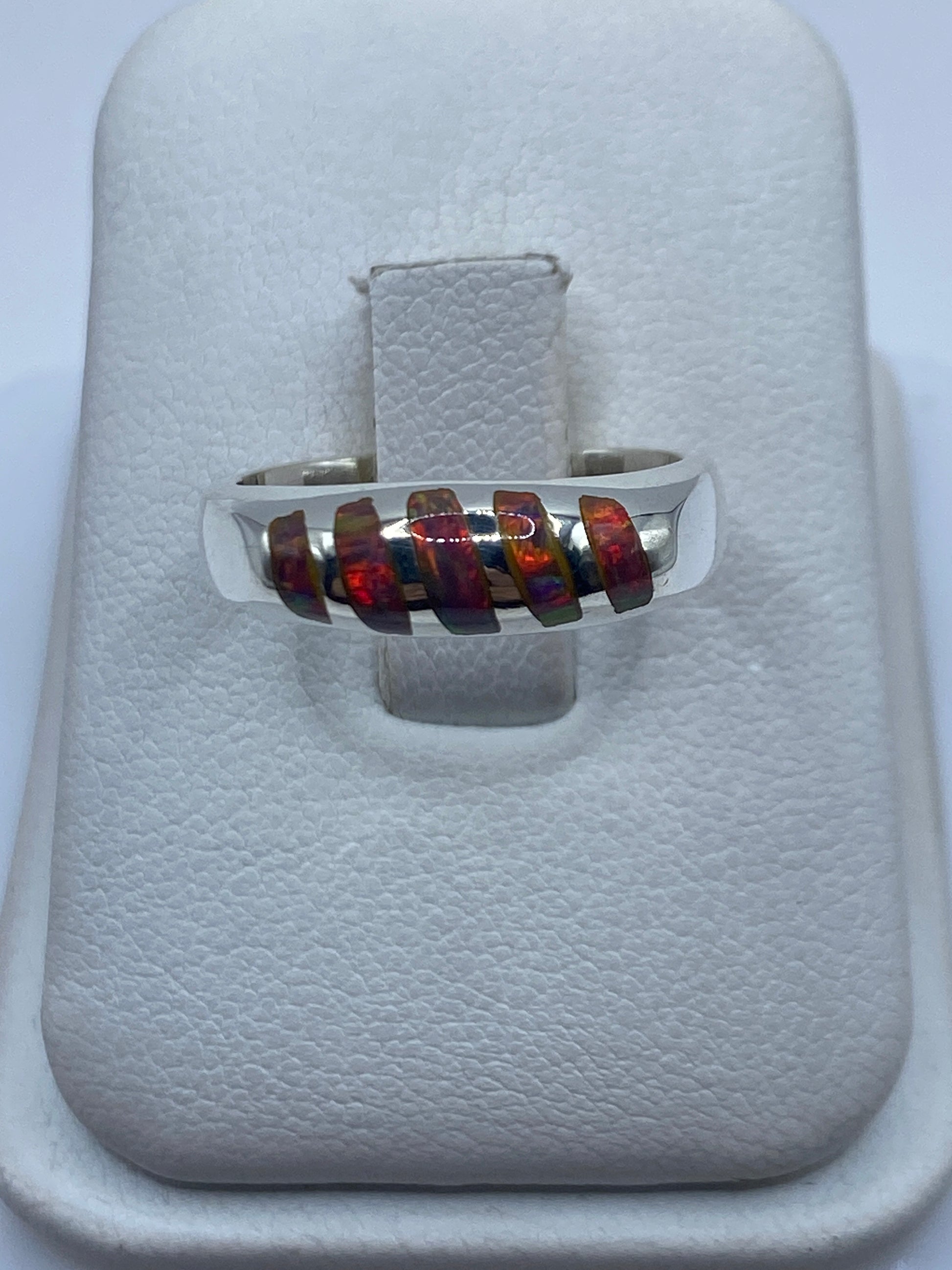 Anillo de plata .950 con ópalo de fuego multicolor mostrando reflejos iridiscentes en la mano