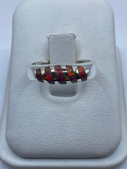 Anillo de plata .950 con ópalo de fuego multicolor mostrando reflejos iridiscentes en la mano