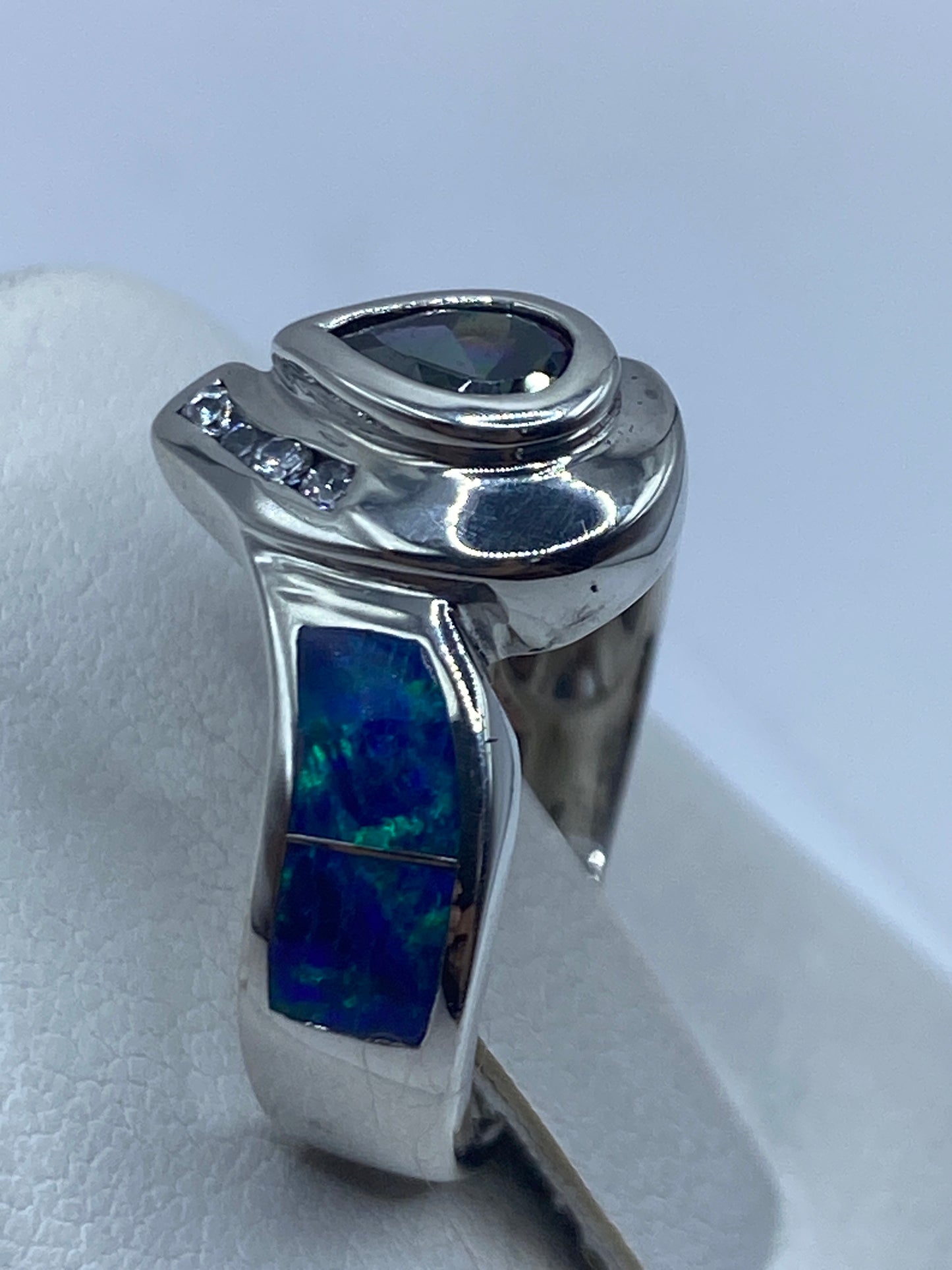 Detalle del ópalo de fuego con destellos azul, verde y naranja sobre mano
