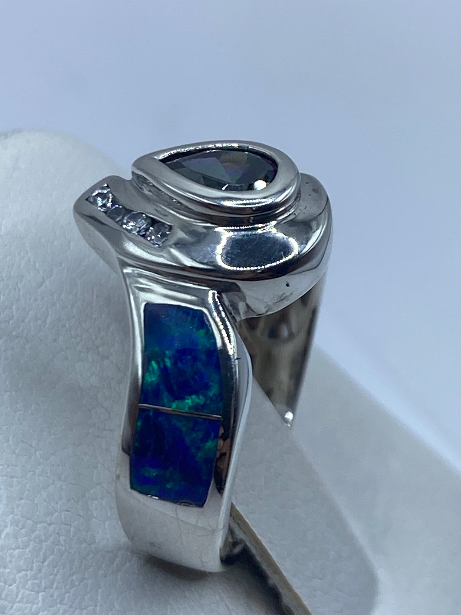 Detalle del ópalo de fuego con destellos azul, verde y naranja sobre mano