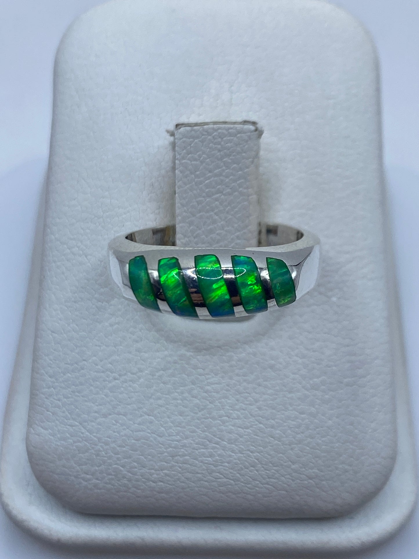 Anillo de plata con ópalo de fuego verde limón engastado en la mano de una mujer