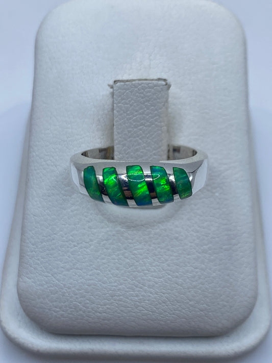 Anillo de plata con ópalo de fuego verde limón engastado en la mano de una mujer
