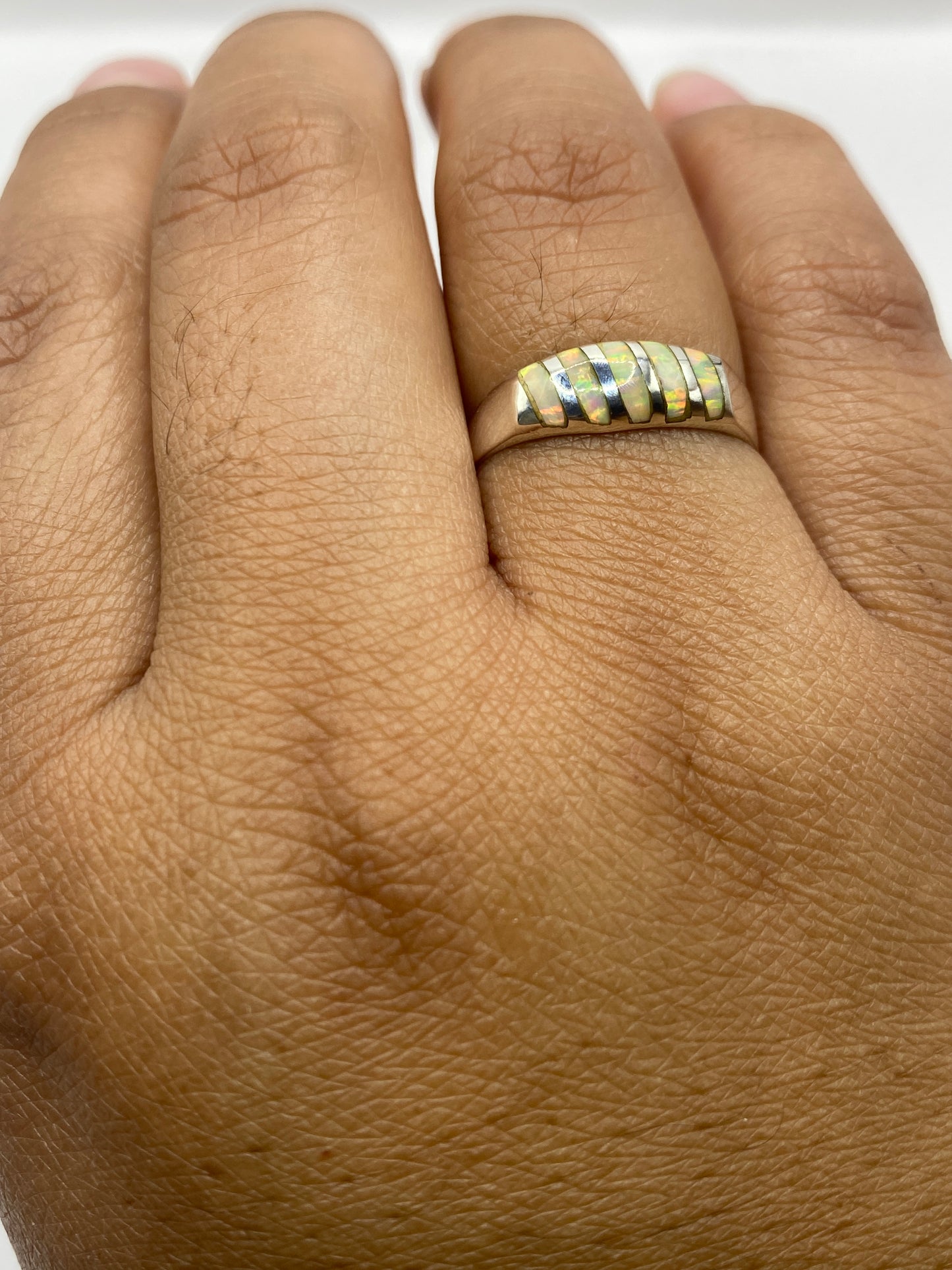 Anillo de plata Ópalo de Fuego en dedo, mostrando el juego de colores único de la piedra