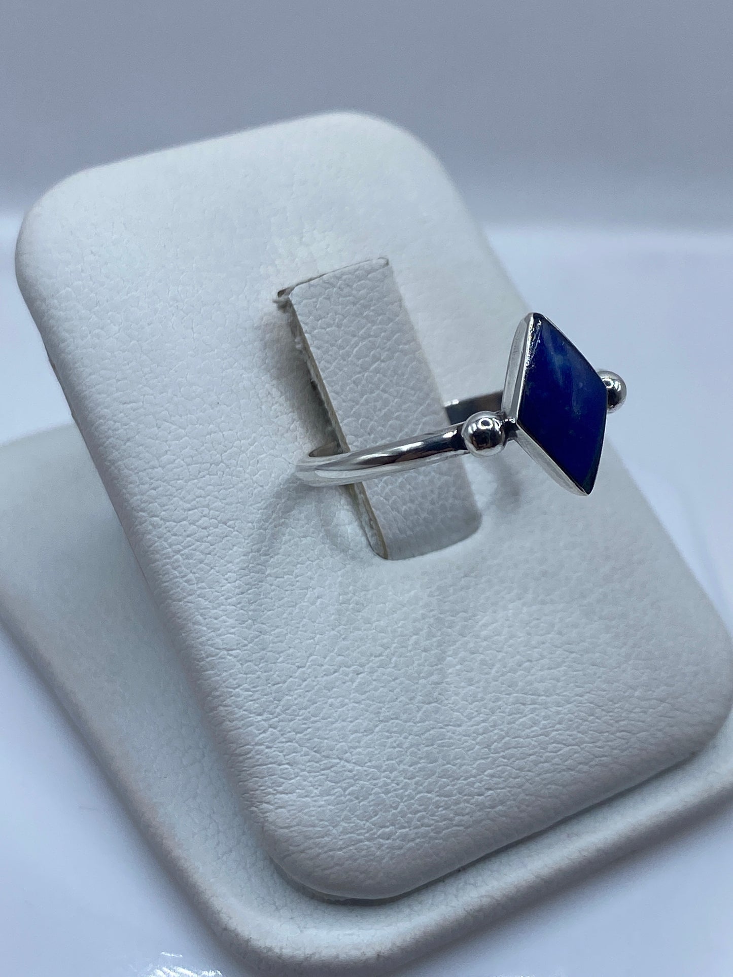 Detalle lateral del anillo solitario mostrando el engaste de lapislázuli en plata .950