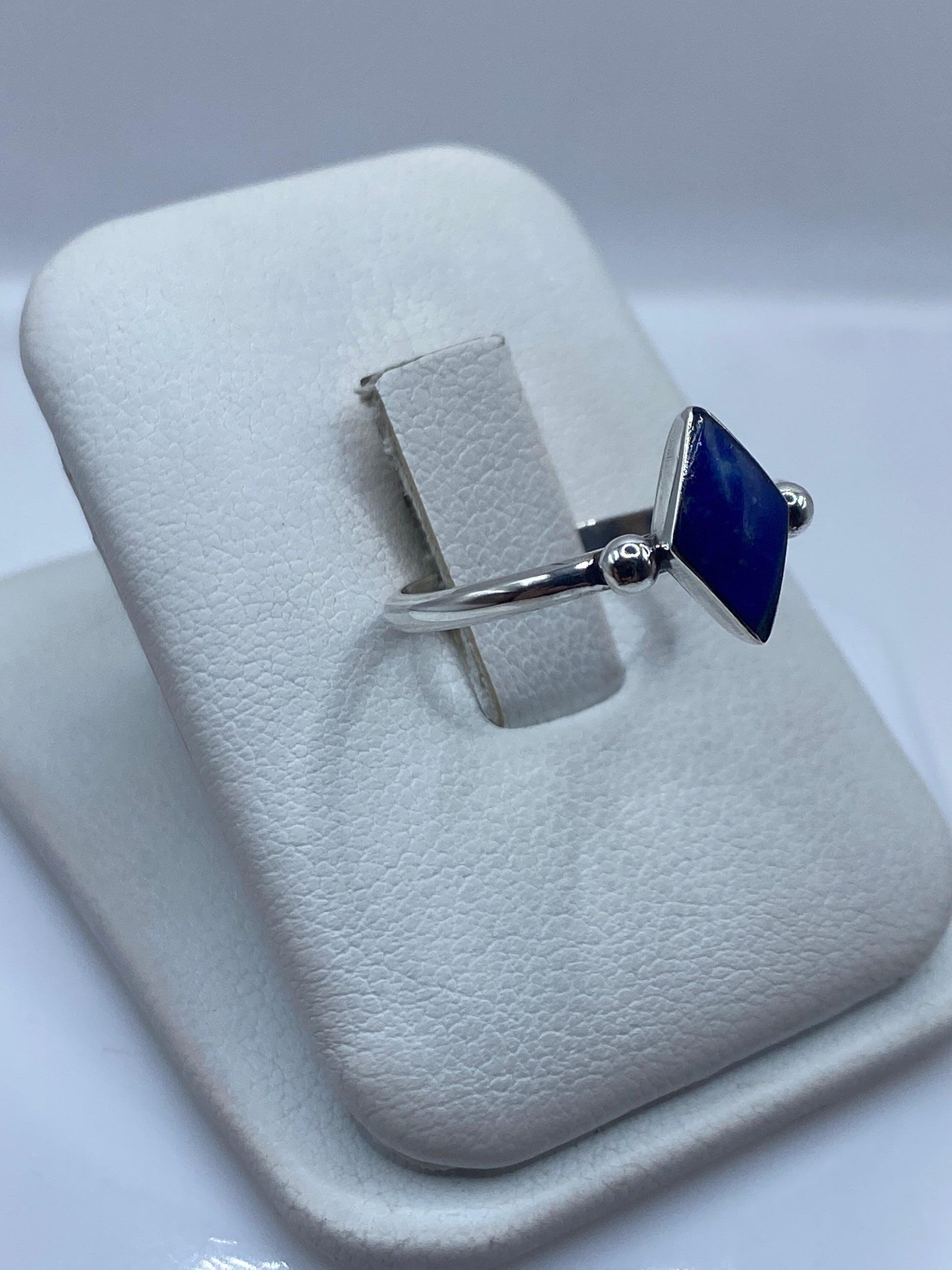 Detalle lateral del anillo solitario mostrando el engaste de lapislázuli en plata .950