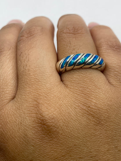 Anillo en dedo mostrando el fuego azul del ópalo bajo luz natural