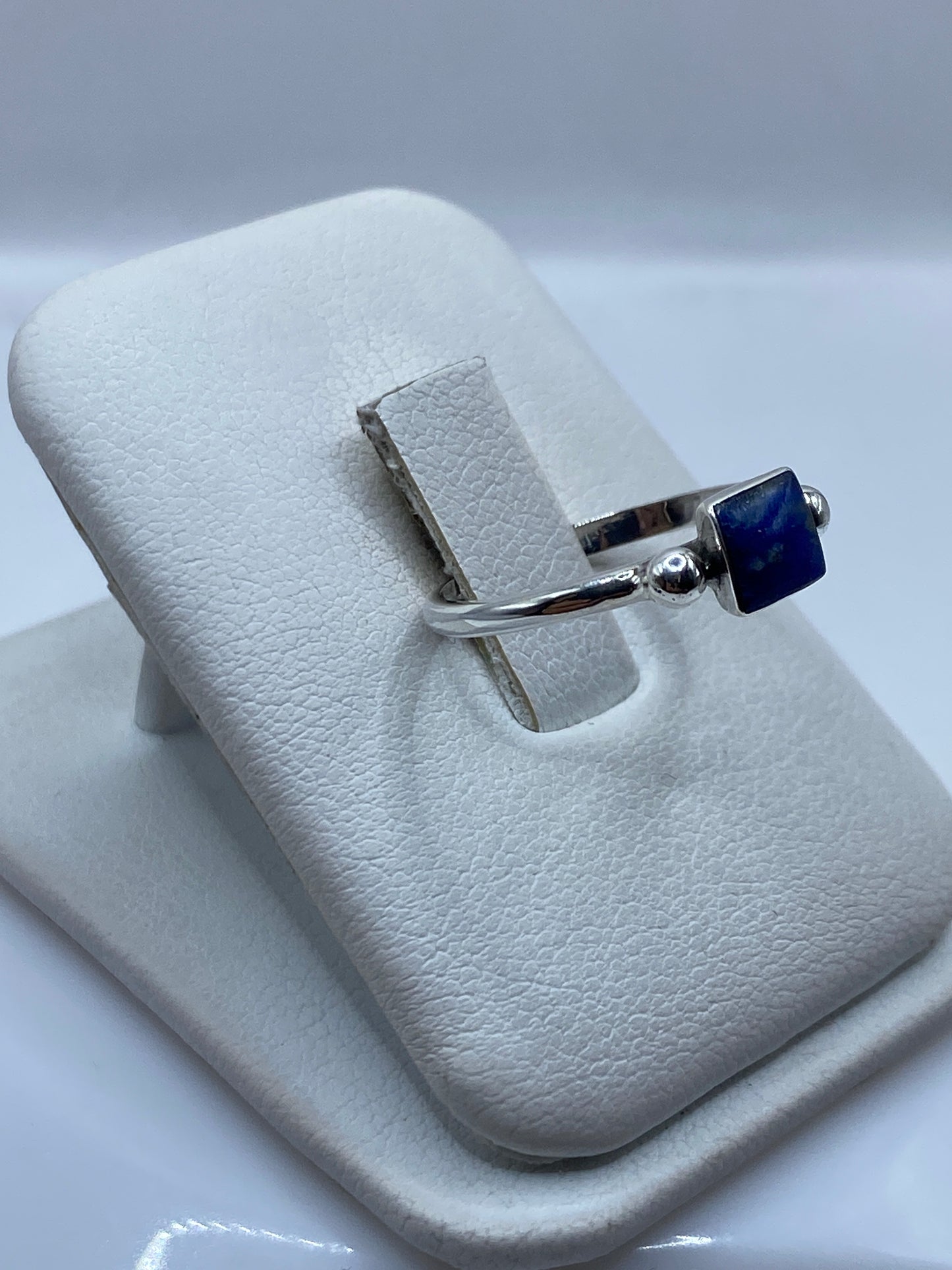 Anillo solitario lapislázuli en mano de mujer, diseño minimalista