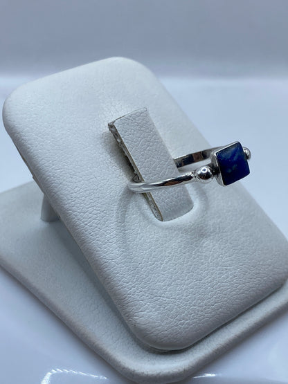 Anillo solitario lapislázuli en mano de mujer, diseño minimalista