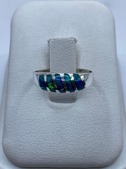 Anillo de plata con ópalo de fuego azul en caja de presentación blanca