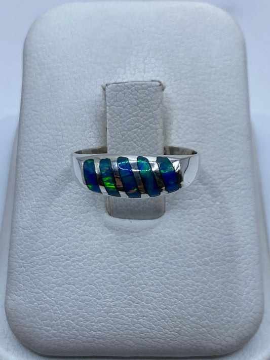 Anillo de plata con ópalo de fuego azul en caja de presentación blanca