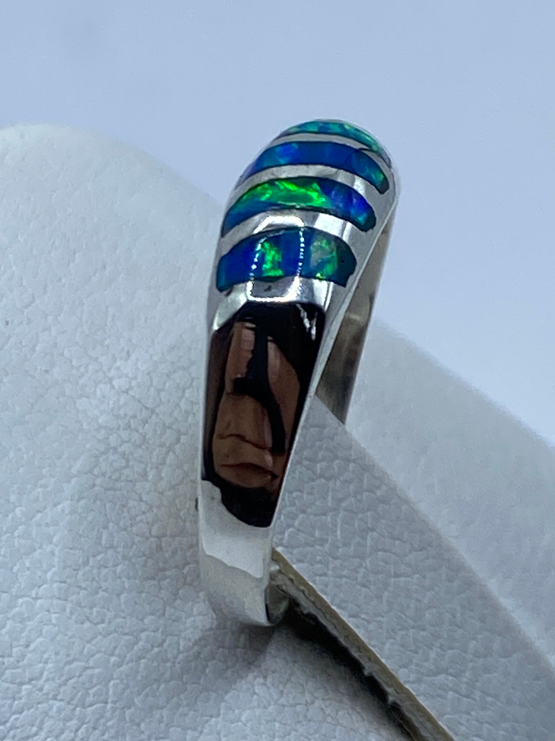 Anillo de plata minimalista con ópalo azul puesto en la mano de una mujer