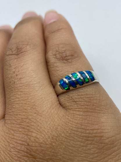 Vista frontal del anillo sobre fondo gris mostrando el sello 925 y el fuego azul del ópalo