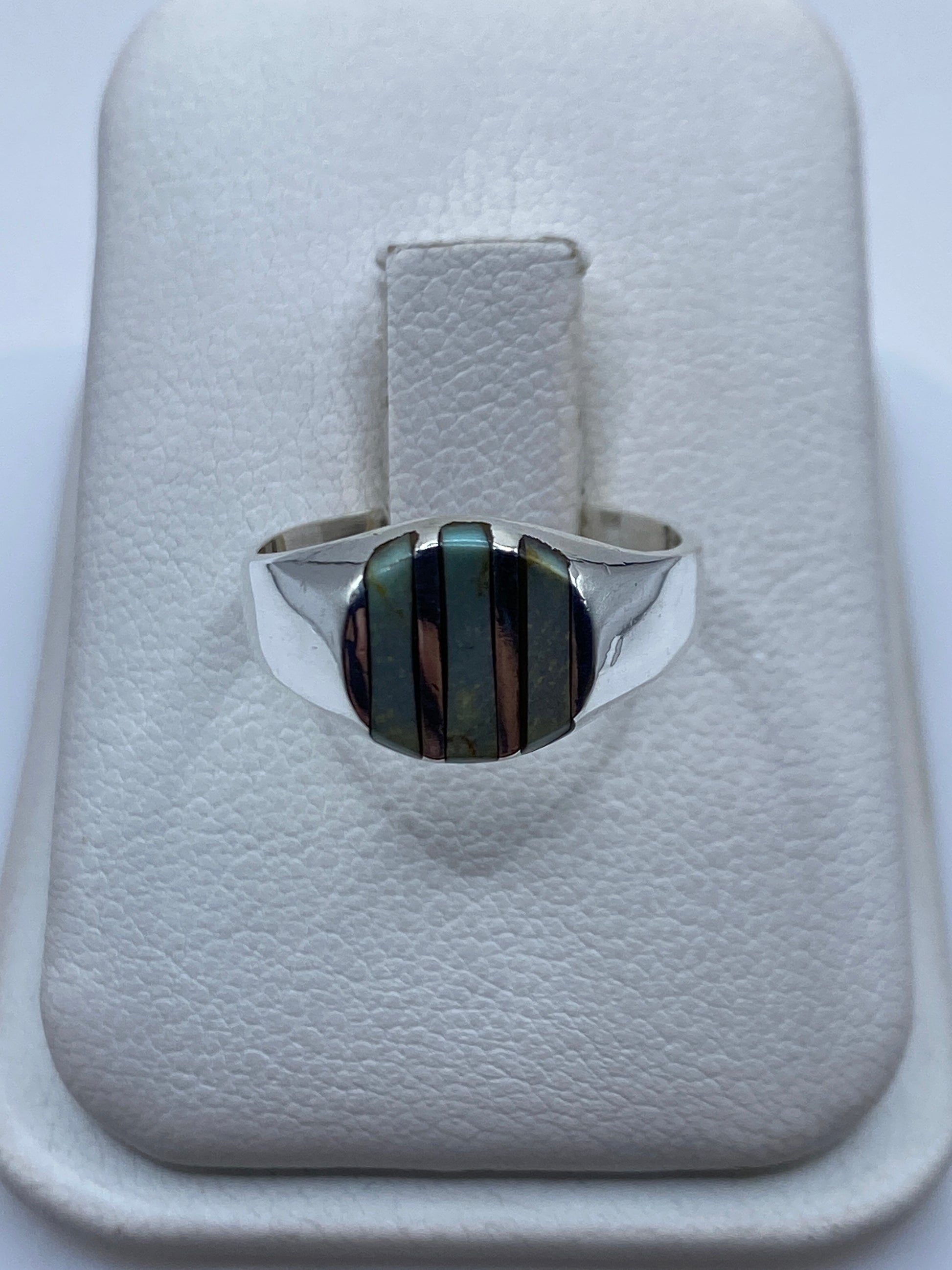 Anillo de plata con onix negro en mano de mujer, vista frontal del engaste