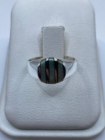 Anillo de plata con onix negro en mano de mujer, vista frontal del engaste