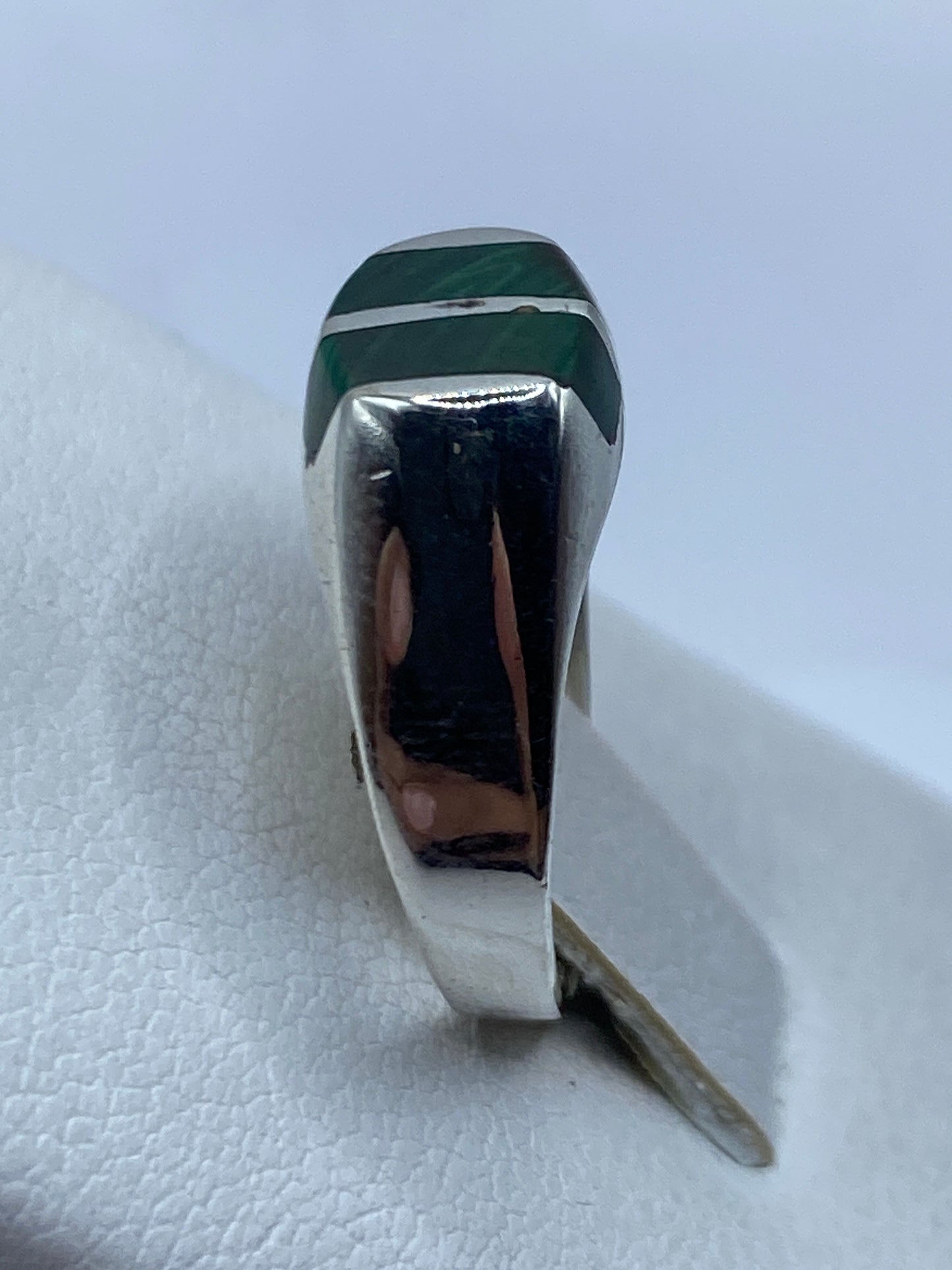 Detalle de la malaquita natural con vetas verdes y negras en plata pulida