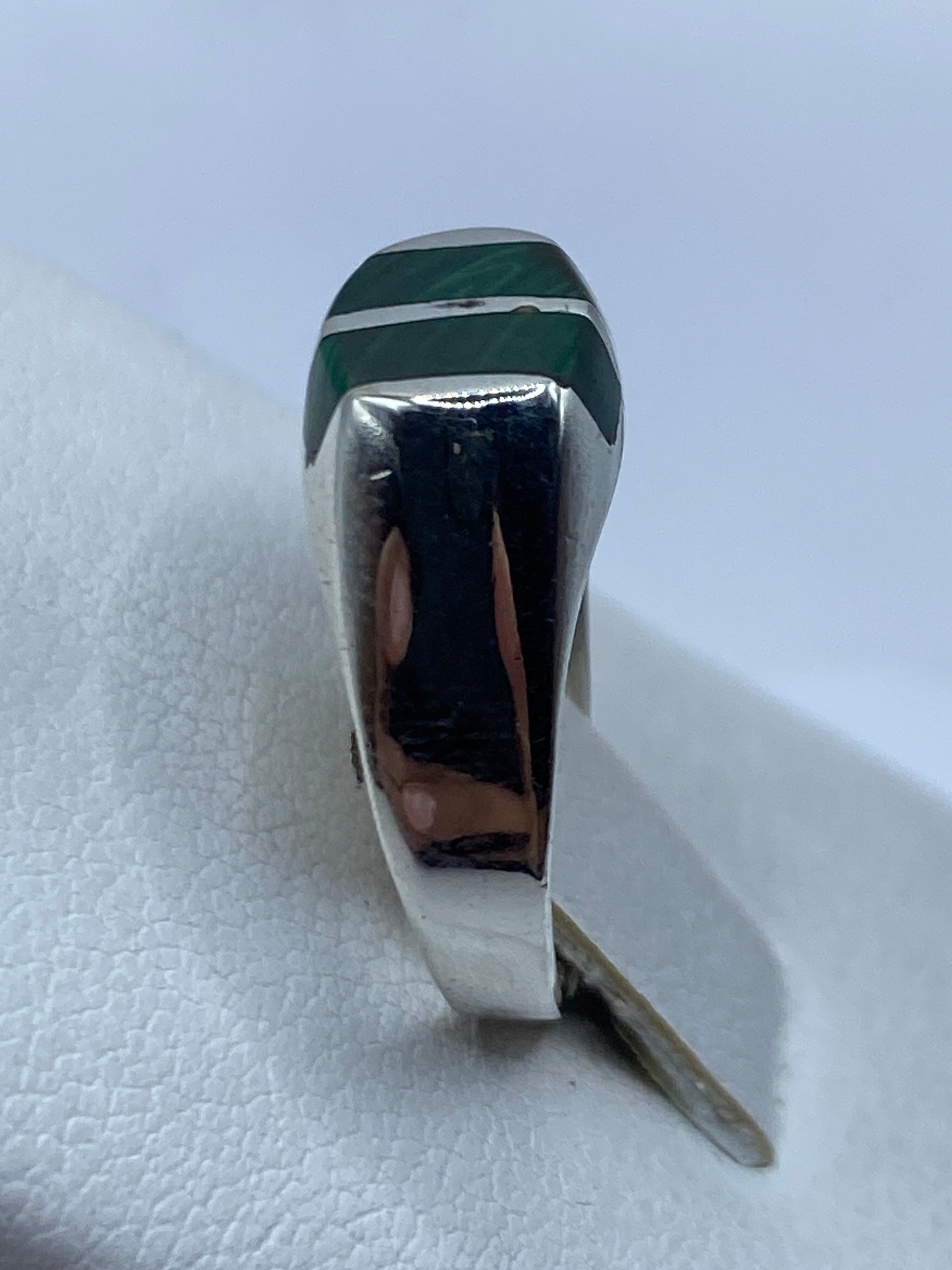 Detalle de la malaquita natural con vetas verdes y negras en plata pulida