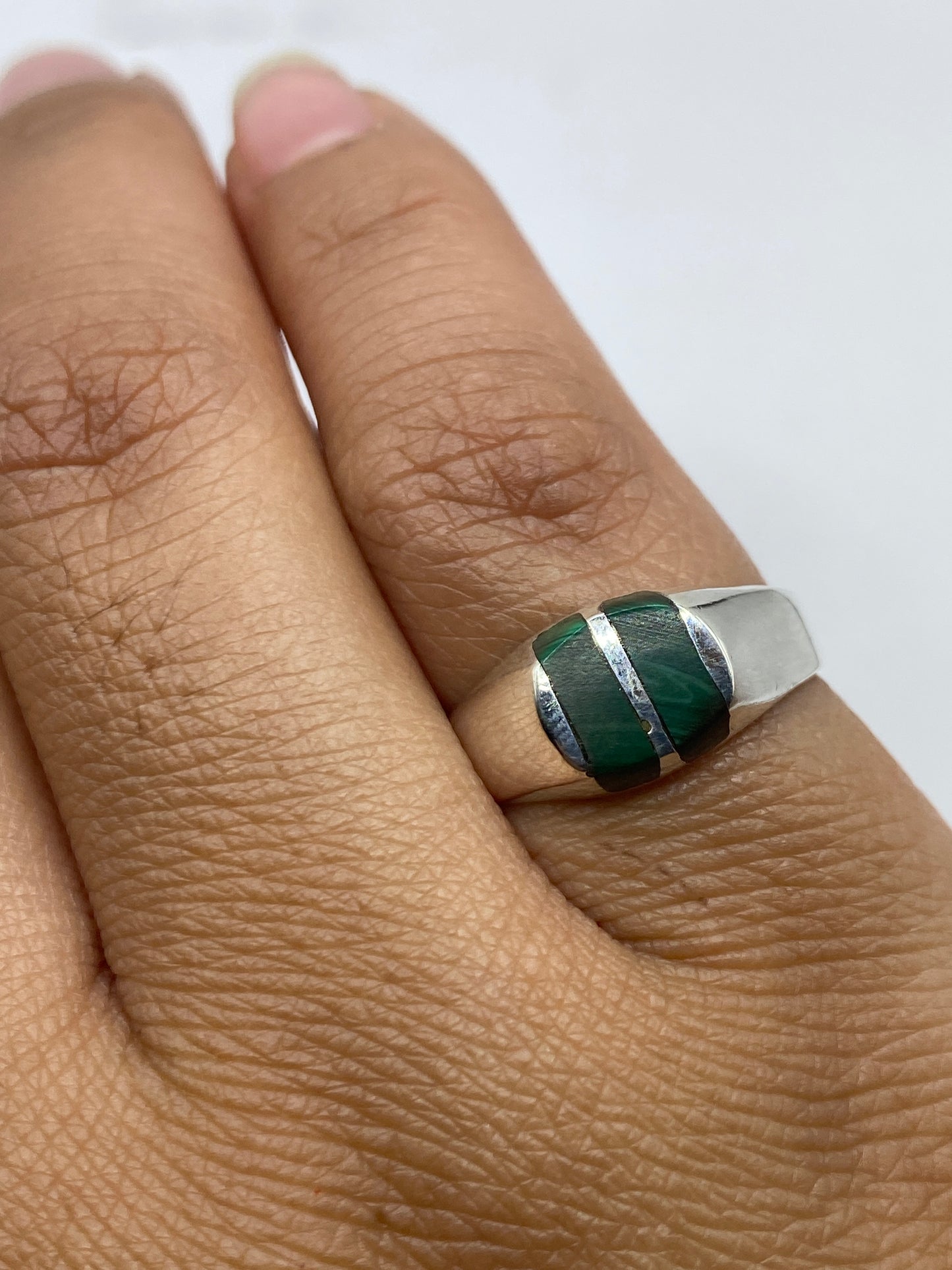 Anillo en dedo mostrando cómo se lleva la banda y el color de la malaquita
