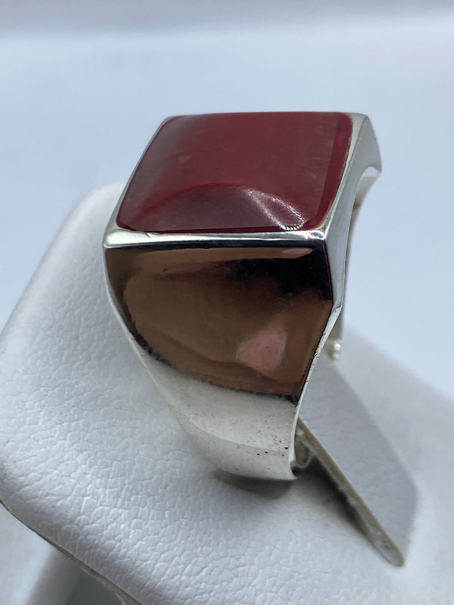 Detalle frontal de la piedra roja en el engaste de plata pulida